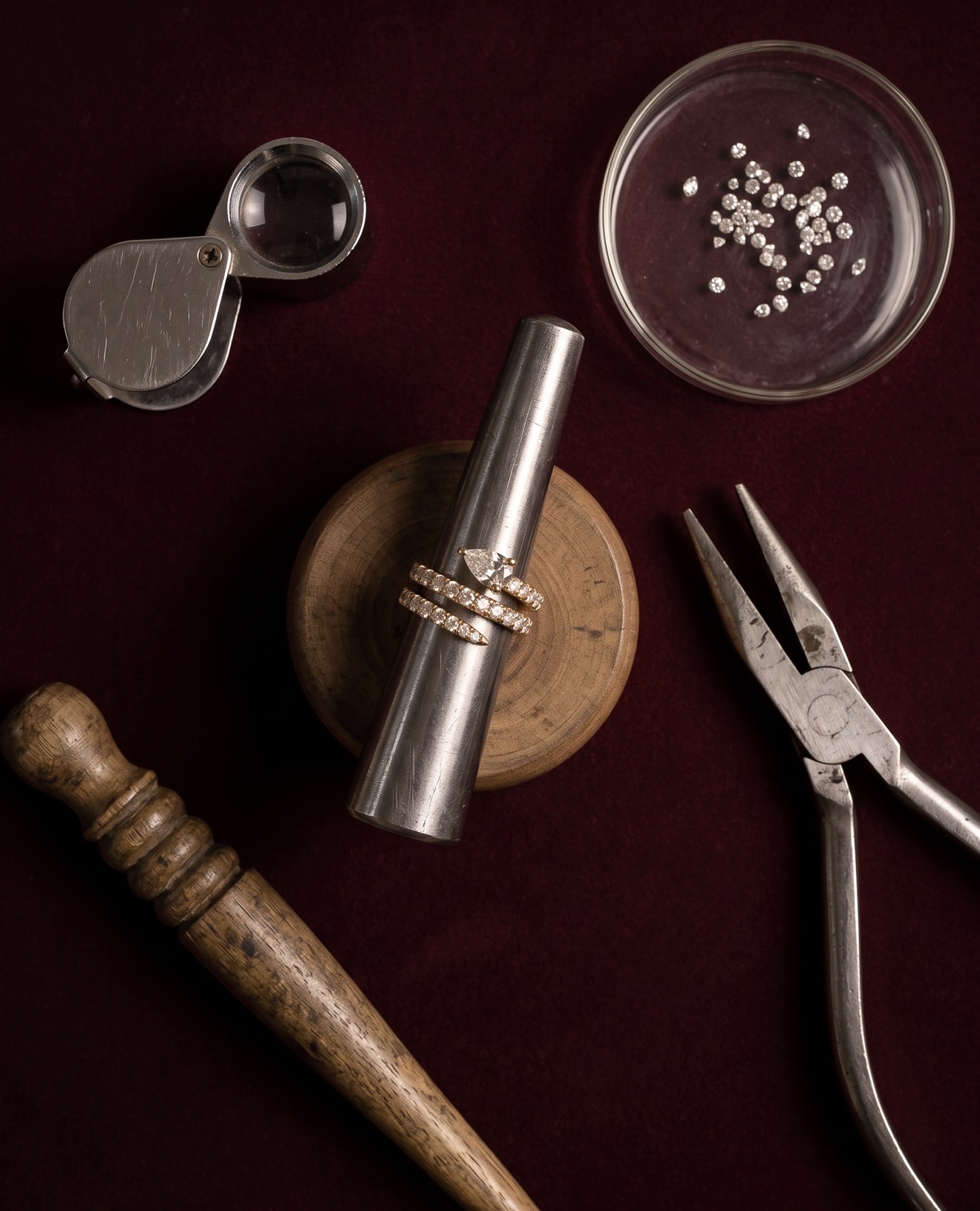 The Diamond Snake Pinky Ring on a ring mandrel among jeweler's tools